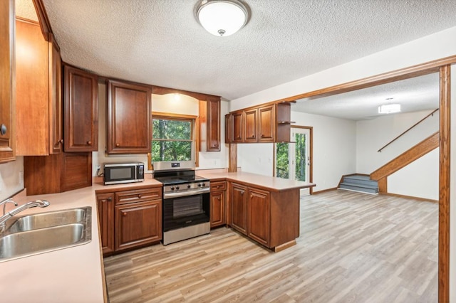 kitchen featuring kitchen peninsula, appliances with stainless steel finishes, sink, and plenty of natural light