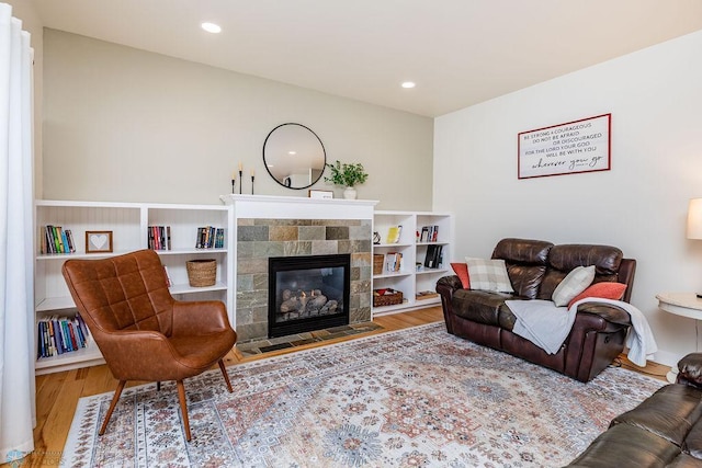 living room featuring a tiled fireplace and hardwood / wood-style floors