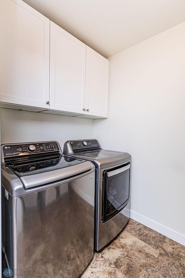 washroom with cabinets and washing machine and clothes dryer