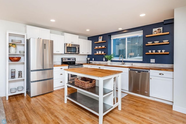 kitchen featuring sink, appliances with stainless steel finishes, wooden counters, and white cabinetry