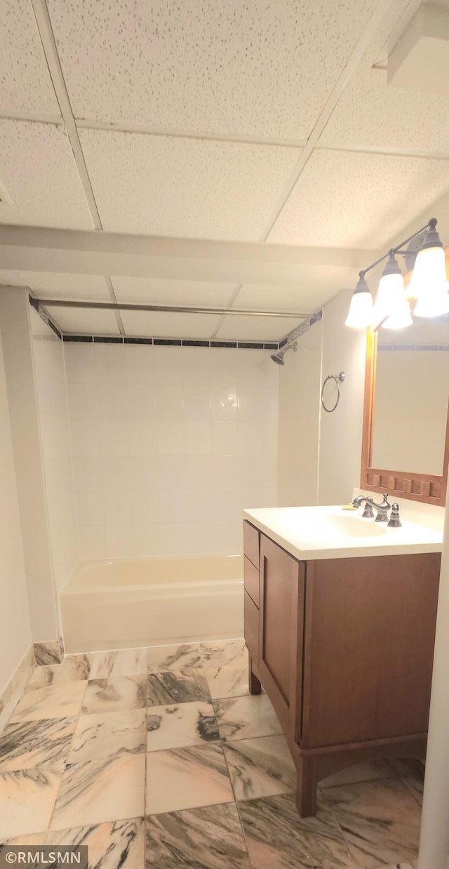 bathroom with bathtub / shower combination, a paneled ceiling, and vanity