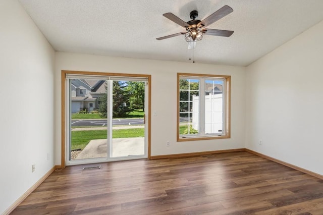 empty room featuring ceiling fan, dark hardwood / wood-style flooring, and a textured ceiling