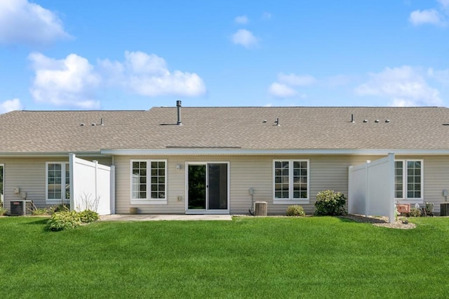 back of house featuring a lawn and central air condition unit