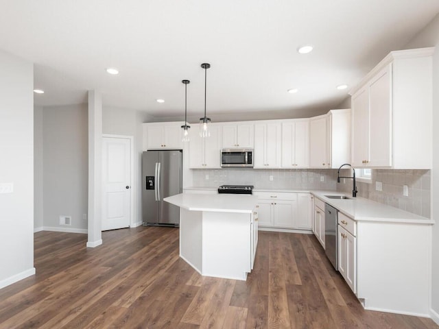 kitchen with white cabinetry, stainless steel appliances, a center island, hanging light fixtures, and sink