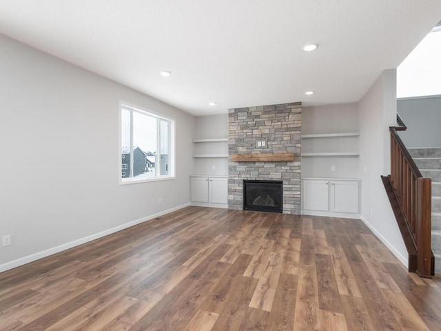 unfurnished living room with dark hardwood / wood-style flooring and a fireplace