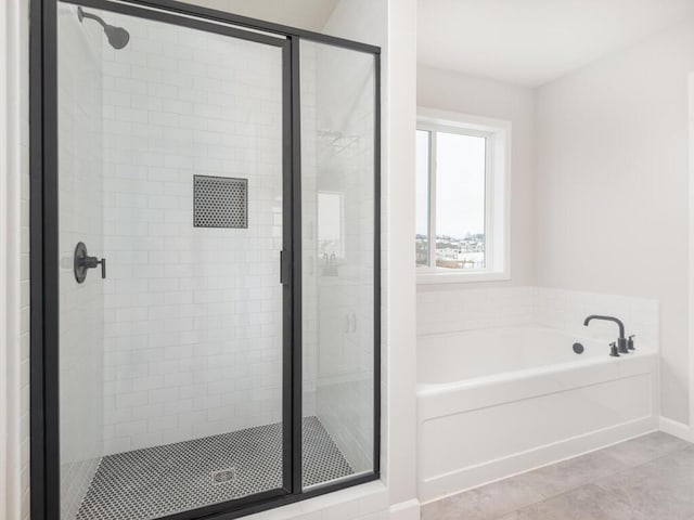 bathroom featuring tile patterned flooring and shower with separate bathtub