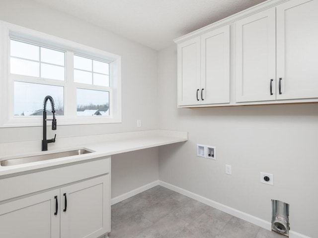 laundry area with sink, hookup for an electric dryer, hookup for a washing machine, and cabinets