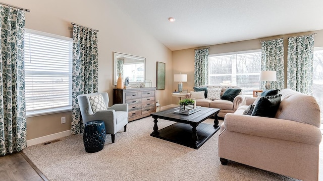 living room featuring light wood-type flooring, plenty of natural light, and vaulted ceiling