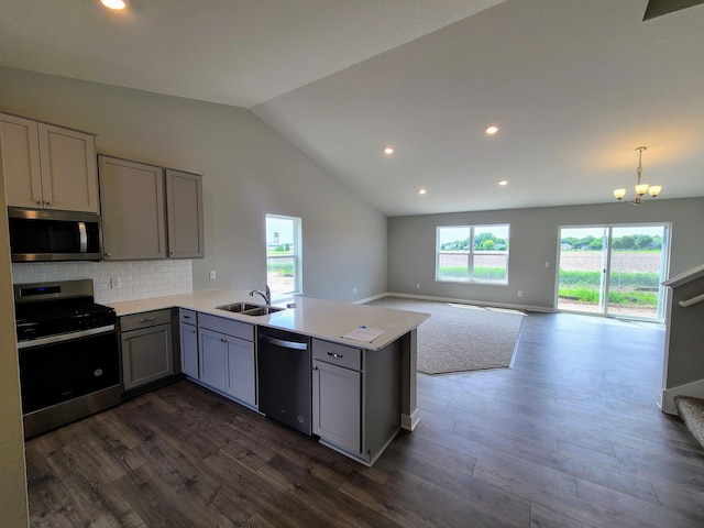 kitchen with sink, gray cabinetry, backsplash, kitchen peninsula, and stainless steel appliances