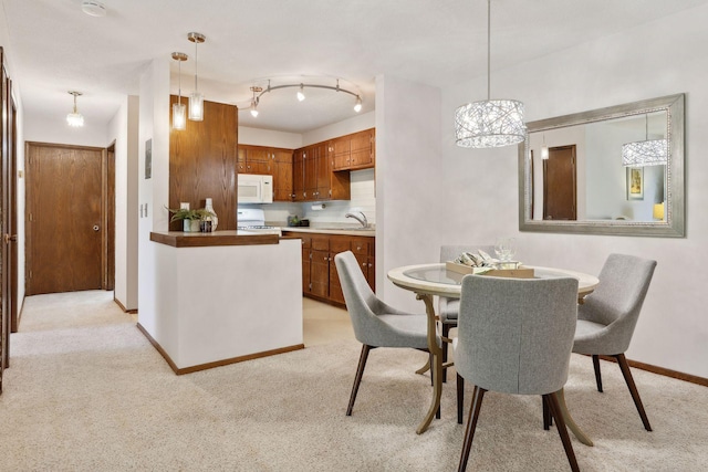 carpeted dining space featuring a notable chandelier and sink