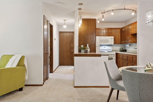 kitchen featuring light carpet, pendant lighting, kitchen peninsula, and white appliances