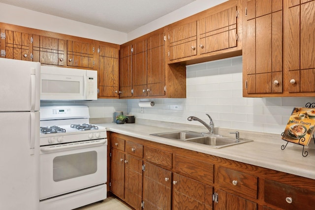 kitchen with sink, tasteful backsplash, and white appliances