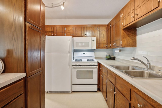 kitchen with sink, white appliances, a textured ceiling, and tasteful backsplash