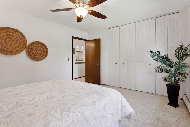 bedroom with ceiling fan, light colored carpet, a baseboard radiator, and a closet