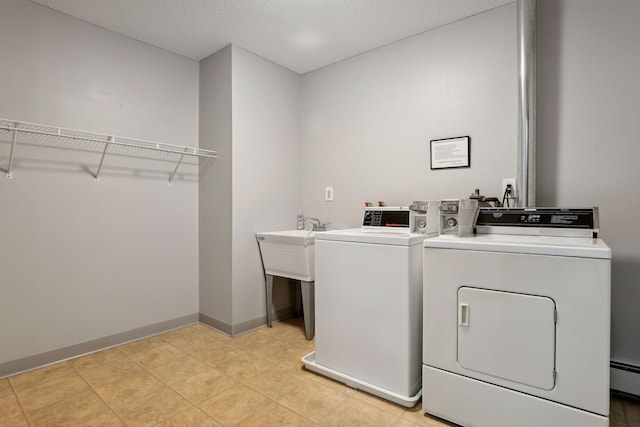 laundry area with separate washer and dryer, a textured ceiling, and a baseboard radiator