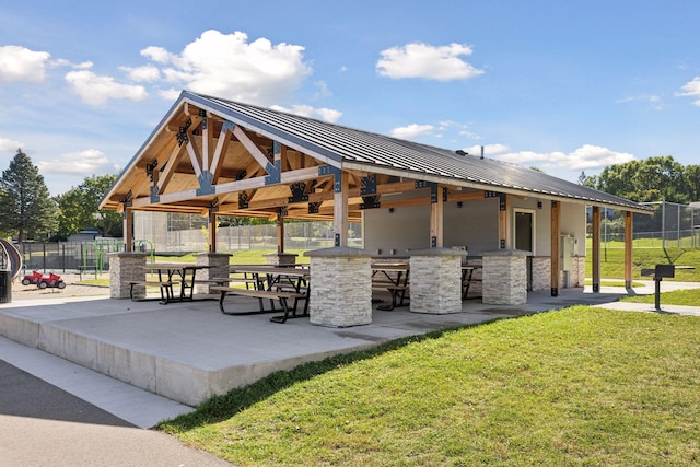 view of community featuring a lawn, a gazebo, an outdoor bar, and a patio area