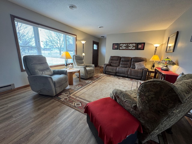 living room featuring a textured ceiling, baseboard heating, and hardwood / wood-style flooring