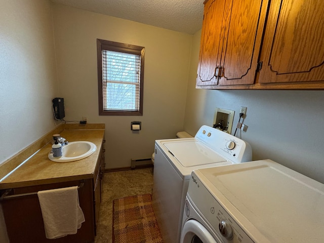 laundry area with sink, washing machine and clothes dryer, a textured ceiling, baseboard heating, and cabinets