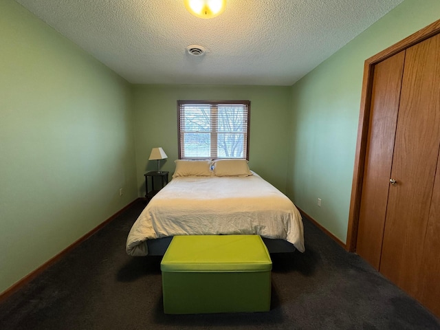 bedroom with carpet floors, a textured ceiling, and a closet