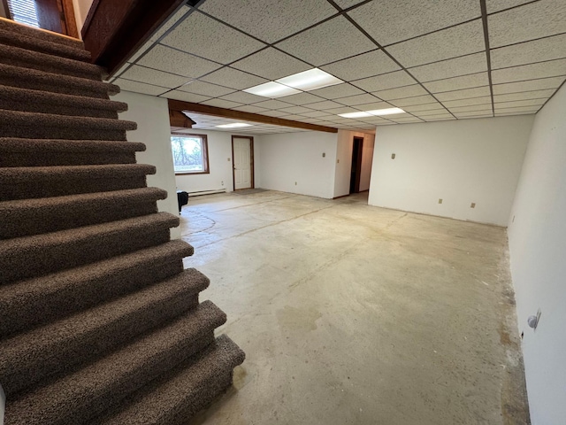 basement with a baseboard heating unit and a drop ceiling