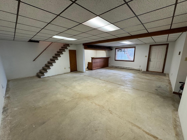 basement with a baseboard heating unit and a paneled ceiling