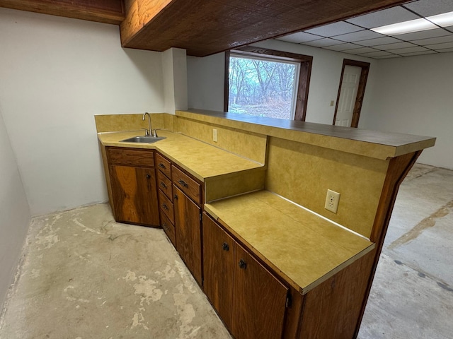 kitchen featuring sink, a paneled ceiling, and kitchen peninsula