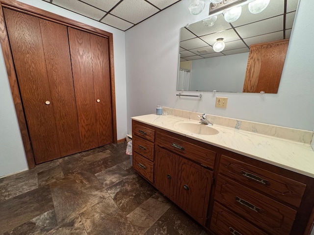 bathroom featuring vanity and a drop ceiling