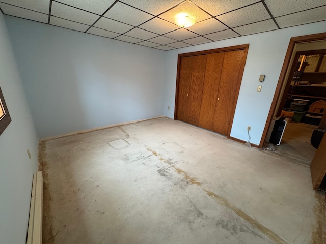 unfurnished bedroom featuring a baseboard heating unit and a closet