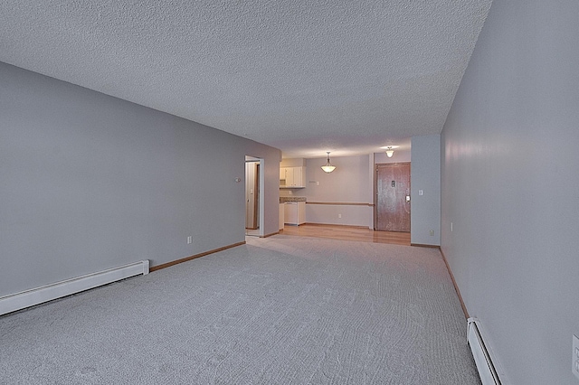 unfurnished room with a textured ceiling and baseboard heating