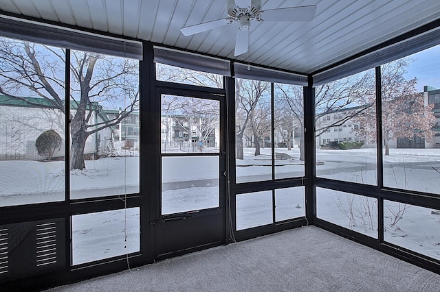 unfurnished sunroom featuring ceiling fan