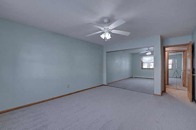 unfurnished bedroom with a baseboard heating unit, light colored carpet, ceiling fan, and a closet