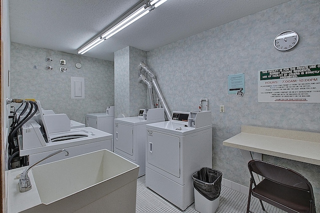 washroom with separate washer and dryer, a textured ceiling, and light tile patterned flooring