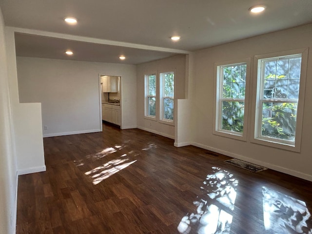 unfurnished living room with dark wood-style flooring, recessed lighting, visible vents, and baseboards