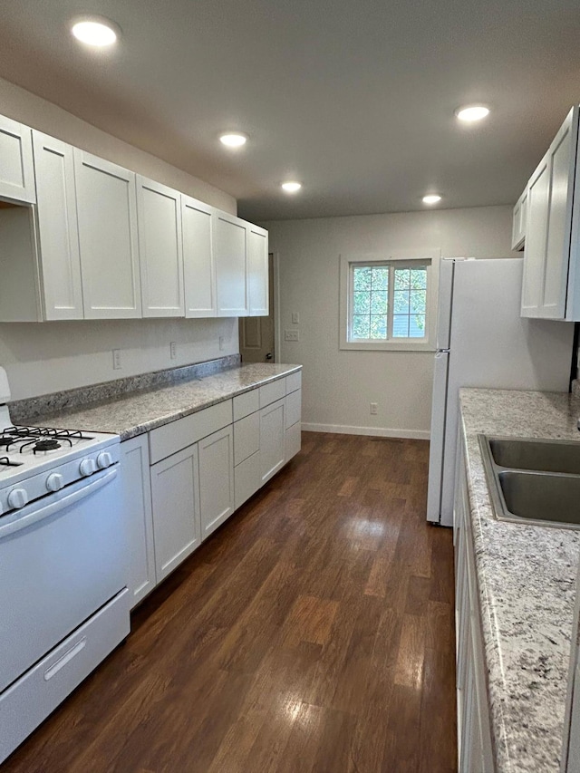 kitchen featuring dark wood finished floors, recessed lighting, light countertops, a sink, and white appliances