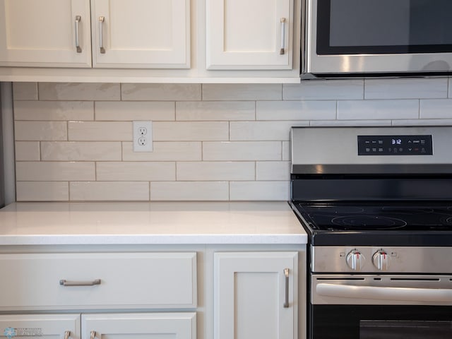 kitchen with tasteful backsplash, stainless steel appliances, and white cabinetry