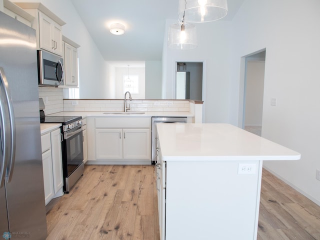 kitchen with stainless steel appliances, decorative backsplash, hanging light fixtures, a kitchen island, and sink