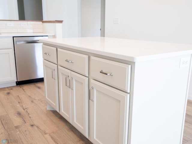 kitchen featuring white cabinets, decorative backsplash, dishwasher, and light hardwood / wood-style flooring