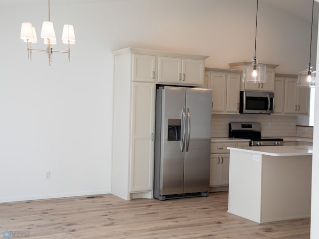 kitchen featuring appliances with stainless steel finishes, tasteful backsplash, light wood-type flooring, pendant lighting, and white cabinets