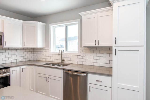 kitchen with decorative backsplash, sink, white cabinetry, and appliances with stainless steel finishes