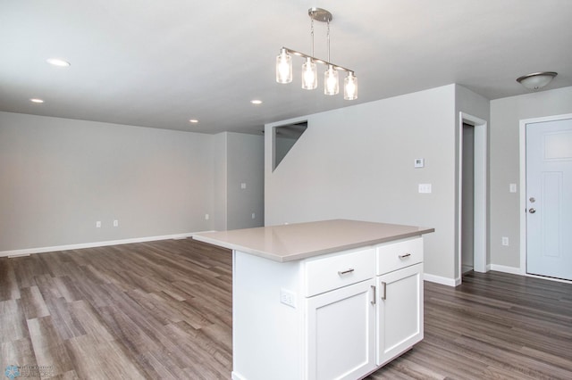 kitchen featuring a kitchen island, white cabinetry, pendant lighting, and dark wood-type flooring