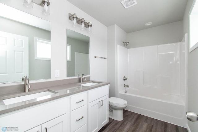 full bathroom featuring hardwood / wood-style floors, toilet, vanity, and bathing tub / shower combination