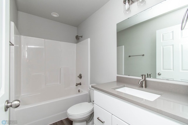 full bathroom with vanity, washtub / shower combination, hardwood / wood-style floors, and toilet