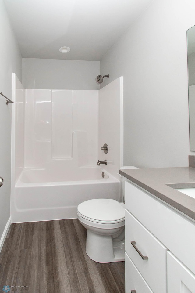 full bathroom with washtub / shower combination, hardwood / wood-style floors, toilet, and vanity