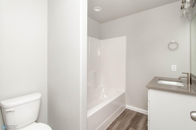 full bathroom with vanity, toilet, hardwood / wood-style floors, and washtub / shower combination