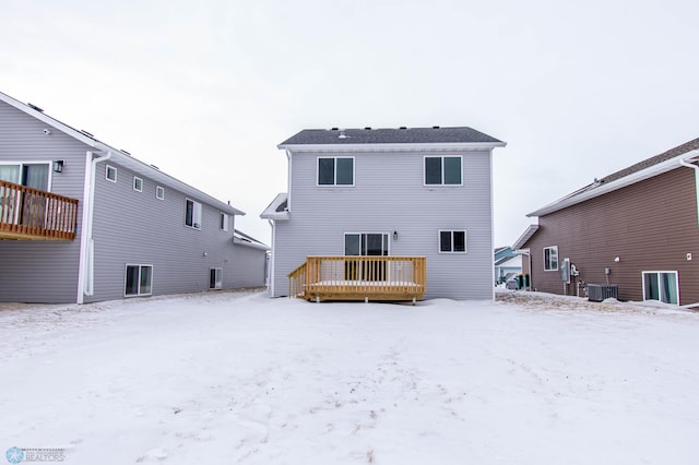 snow covered property featuring central AC unit and a wooden deck