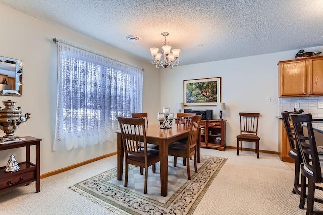 dining area featuring light colored carpet, an inviting chandelier, and a textured ceiling