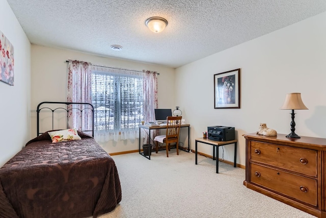 bedroom with a textured ceiling and light colored carpet