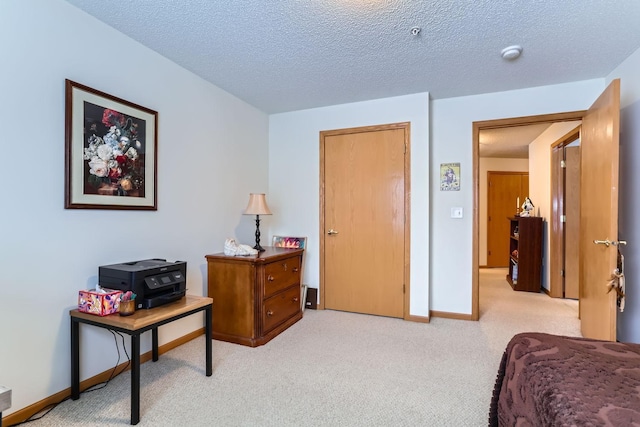 bedroom featuring a textured ceiling and light colored carpet