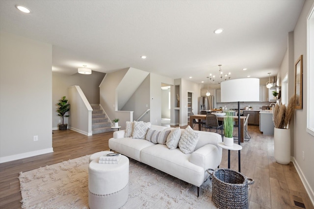 living room featuring a chandelier and light hardwood / wood-style floors