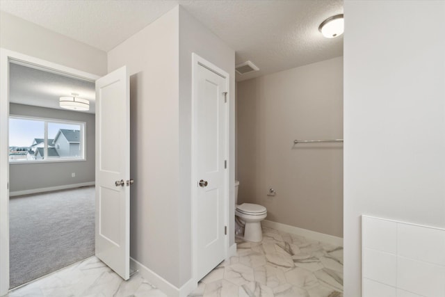 bathroom with toilet and a textured ceiling